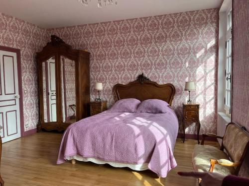 a bedroom with a bed with a purple blanket at Castel Saint Laurent in Langeais