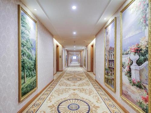 an empty hallway with paintings on the walls at Vienna Hotel Jiangsu Suzhou Wujiang Bus Passenger Station in Hubin