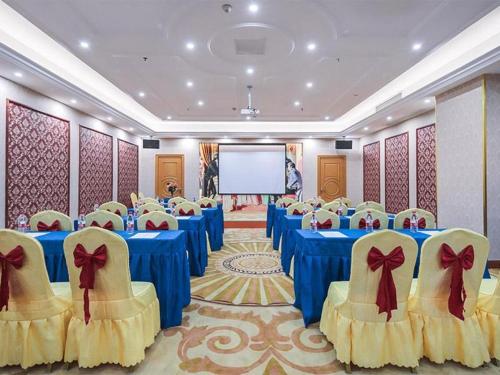 a conference room with blue tables and chairs and a screen at Vienna Hotel Jiangsu Suzhou Wujiang Bus Passenger Station in Hubin