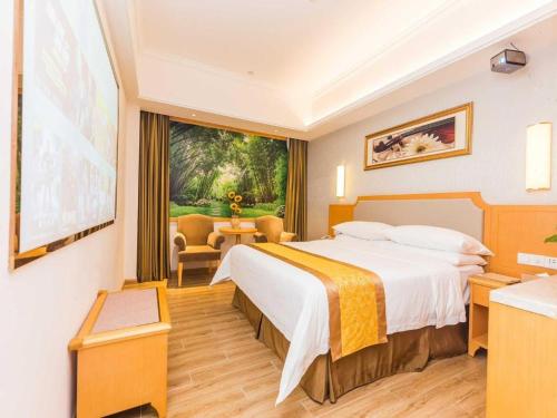 a hotel room with a large bed and a window at Vienna Hotel Guangdong Foshan Wenhua North Road in Nanhai