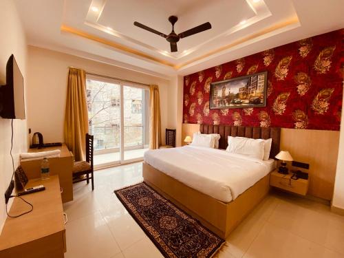 a bedroom with a bed with a red wall at Hotel DSR Corporate Suite Sector 45 Gurgaon in Gurgaon