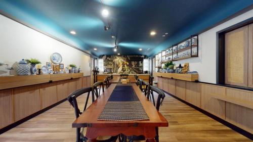 uma sala de jantar com uma mesa longa e cadeiras em Eat Sleep Chann em Chanthaburi