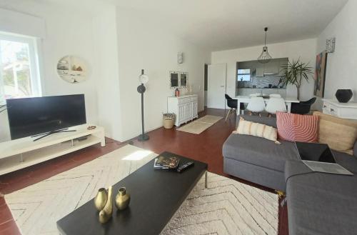 a living room with a couch and a tv at Garden Luz House in Lagos