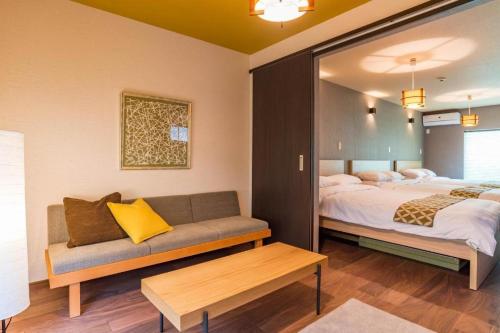 大阪市にあるBijou Suites Kakomiのベッドルーム1室(ベッド1台、ソファ付)