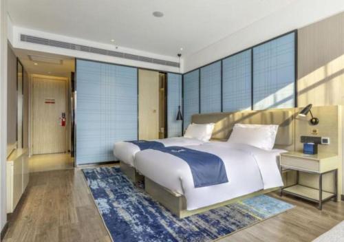 1 dormitorio con cama grande y ventana grande en Echarm Hotel Quanzhou Liming Vocational University Ling Show World en Donghai