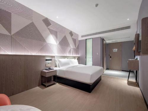 a bedroom with a large white bed in a room at Borrman Hotel Wuzhou College Fumin Road in Wuzhou