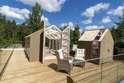a wooden deck with two chairs and a gazebo at Kosta Lodge in Kosta