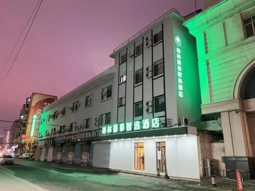 瀋陽的住宿－Green Tree Inn Shenyang Middle Street，建筑的一侧有绿色标志