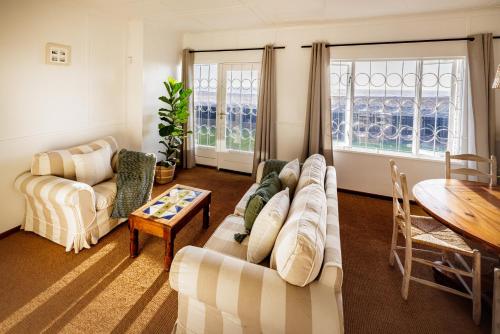 uma sala de estar com dois sofás e uma mesa em Swakopmund Seafront Cottage em Swakopmund
