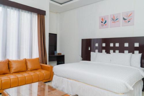 sypialnia z dużym łóżkiem i kanapą w obiekcie Hotel Mireya Sorowako w mieście Saroako