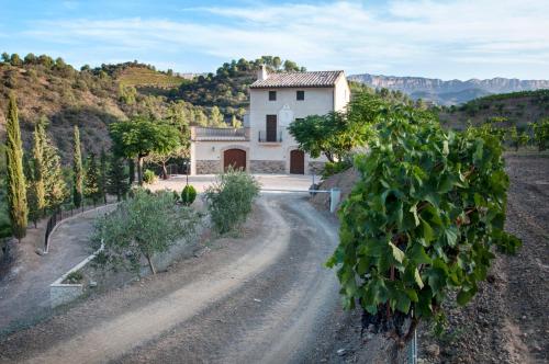 a house in the middle of a dirt road at MAS ALSERA. Masoveria d'Agroturisme in Torroja