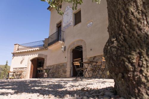 a building with tables and chairs in front of it at MAS ALSERA. Masoveria d'Agroturisme in Torroja