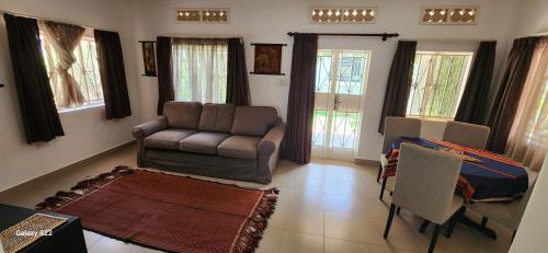a living room with a couch and a chair at Kamuli Cottage in Entebbe