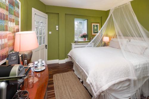 a bedroom with green walls and a bed with a canopy at Barnabrow Country House in Killinagh