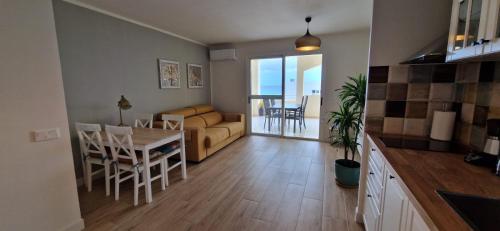 eine Küche und ein Wohnzimmer mit einem Sofa und einem Tisch in der Unterkunft Blue Lagoon Apartment in Costa Calma