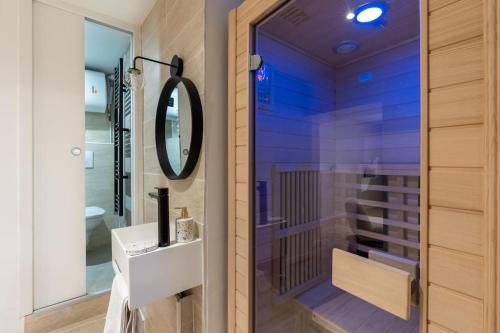 une salle de bain avec un lavabo et un miroir dans l'établissement NEW - Appartement Luxeux avec Cinema et Sauna, à Paris