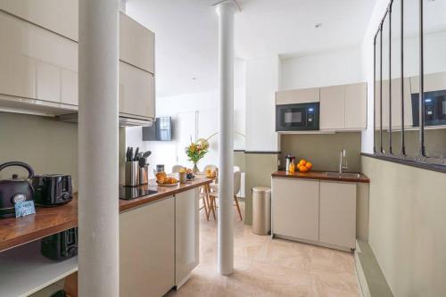 une cuisine avec des armoires blanches et un comptoir dans l'établissement NEW - Appartement Luxeux avec Cinema et Sauna, à Paris