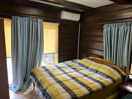 Schlafzimmer mit einem Bett und einem Fenster mit Vorhängen in der Unterkunft Villa Nikitas in Konia