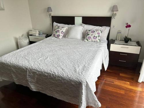 - une chambre avec un grand lit blanc et des oreillers dans l'établissement Excepcional chalet en Perbes, à Miño