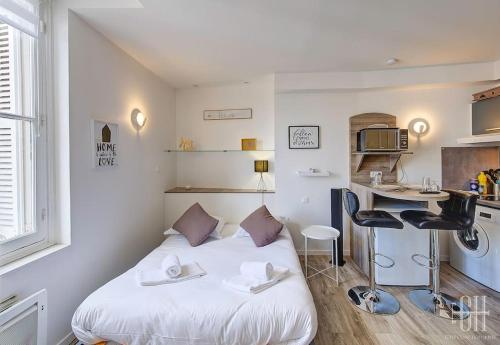 Cette petite chambre comprend un lit blanc et un bureau. dans l'établissement Le Traversière 5 / Proche Gare, à Tours