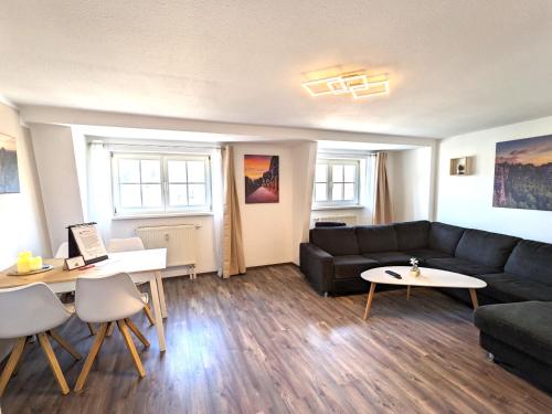 a living room with a couch and a table at HW4B - Urlaubsmagie - Zentral mit Gemeinschaftsgarten, -Pool, -Sauna & Whirlpool in Sebnitz