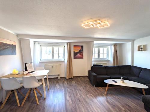 a living room with a couch and a table at HW4B - Urlaubsmagie - Zentral mit Gemeinschaftsgarten, -Pool, -Sauna & Whirlpool in Sebnitz