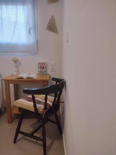 a chair sitting at a desk with a book at Creta Irini's Rooms Παραδοσιακά for you in Tympáki