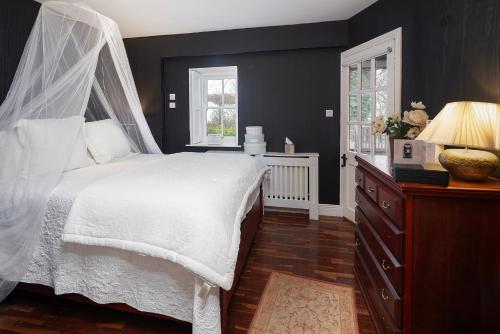 a bedroom with a white bed with a canopy at Barnabrow Country House in Killinagh