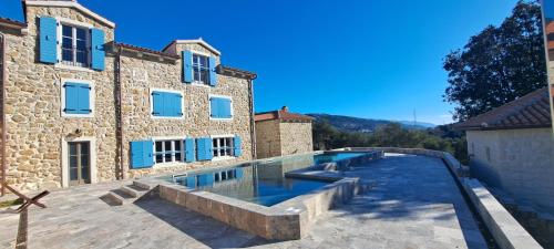 a swimming pool in front of a building at Deluxe Nature Resort Galovi Dvori in Rab