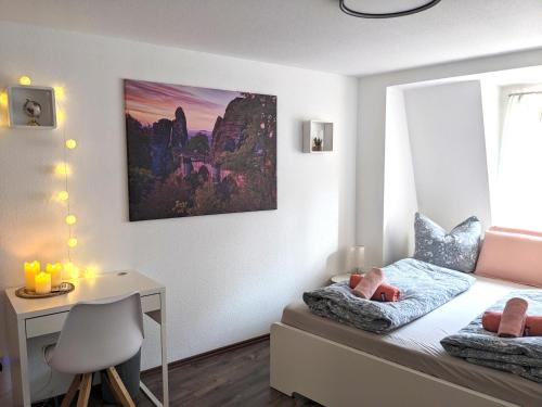 a small bedroom with a bed and a desk and a window at HW4B - Urlaubsmagie - Zentral mit Gemeinschaftsgarten, -Pool, -Sauna & Whirlpool in Sebnitz