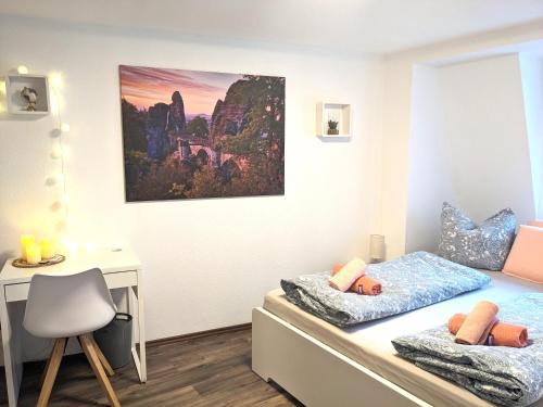 a bedroom with two beds and a desk at HW4B - Urlaubsmagie - Zentral mit Gemeinschaftsgarten, -Pool, -Sauna & Whirlpool in Sebnitz