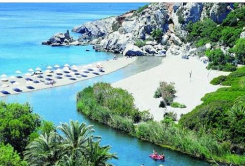 a beach with a boat in the water at Creta Irini's Rooms Παραδοσιακά for you in Tympáki