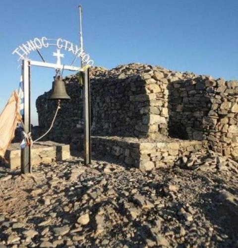 a bell on the side of a stone building at Creta Irini's Rooms Παραδοσιακά for you in Tympáki