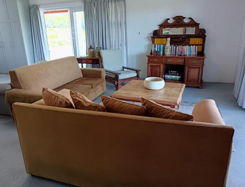 ein Wohnzimmer mit einem Sofa und einem Couchtisch in der Unterkunft Blombos Self-Catering House in Franskraalstrand
