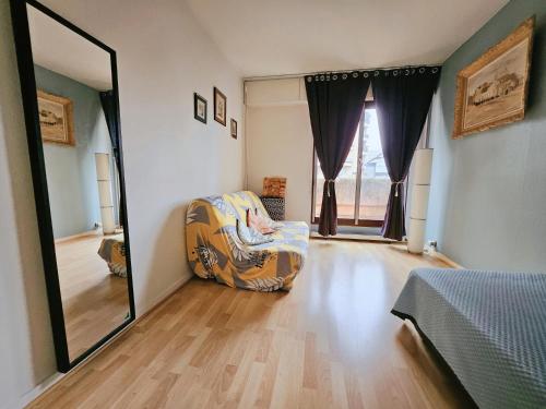 una camera da letto con una sedia e un grande specchio di Belle Chambre a Créteil
