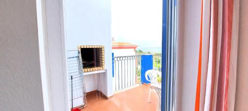 a room with a balcony with a fireplace at Beach House Espartal - Monte Clerigo - Aljezur in Vales