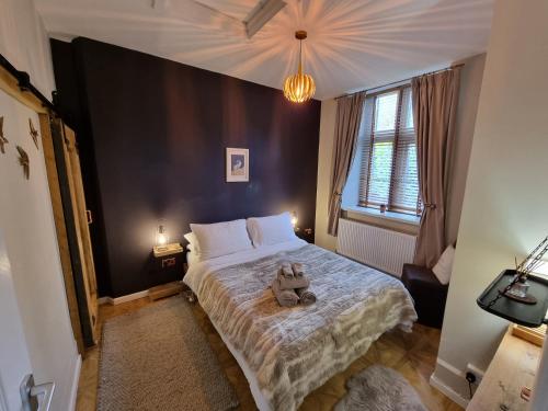 a bedroom with a bed with a stuffed animal on it at Chambers Apartment @ The Old Magistrates in Betws-y-coed