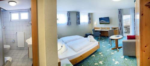 フラドゥンゲンにあるHotel Sonnentauのベッドとバスルームが備わる客室です。