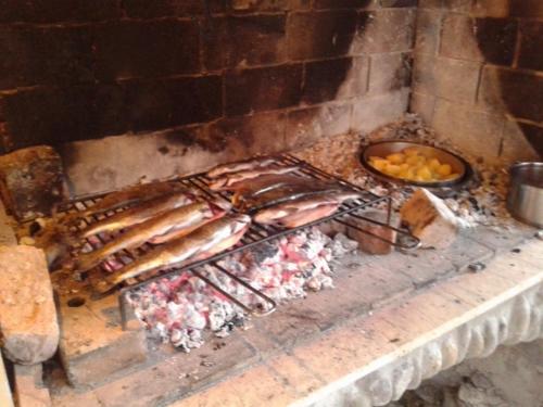 a grill with meat and a bowl of fruit at Holiday House Sobol in Kuželj