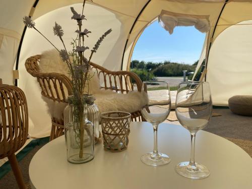 einen Tisch mit drei Weingläsern auf einem Zelt in der Unterkunft Marsk Camp in Skærbæk