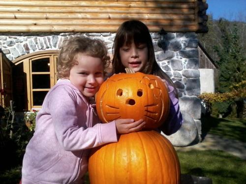 two young girls standing next to a pumpkin at Holiday House Sobol in Kuželj