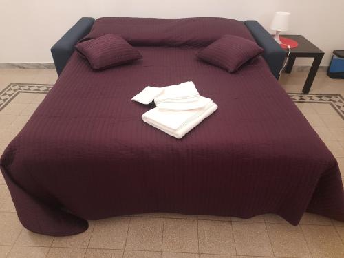 a purple bed with two towels on top of it at Delizioso appartamento al Pigneto in Rome