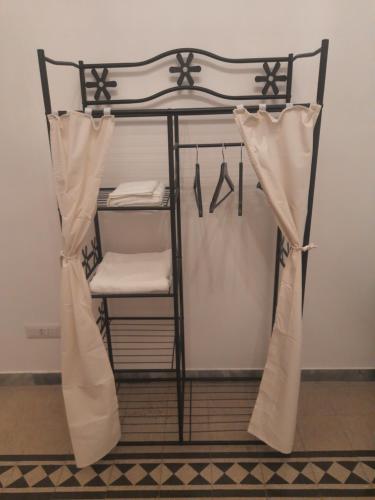 a iron bunk bed with white sheets and curtains at Delizioso appartamento al Pigneto in Rome