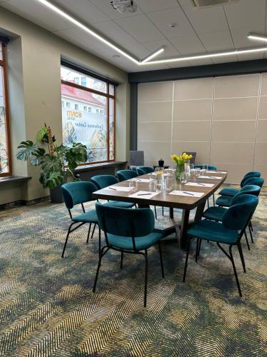 ヴィリニュスにあるCONTI HOTEL VILNIUS, Conference Centre, Restaurant & Barの大きなテーブルと椅子付きの会議室を利用できます。