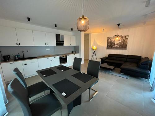 eine Küche und ein Wohnzimmer mit einem Tisch und einem Sofa in der Unterkunft Siegduo in Siegburg
