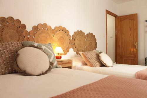 um quarto com 2 camas e uma cabeceira em madeira em Casa Tekas - Centro Ciudad em Caravaca de la Cruz