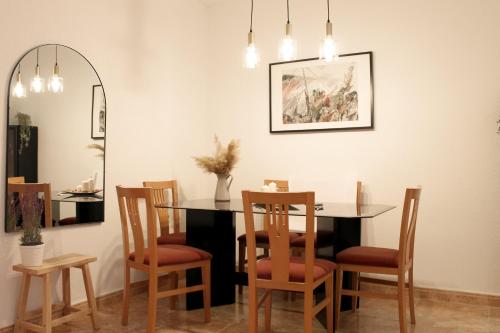 Casa Tekas - Centro Ciudad في كارافاكا دي لا كروز: غرفة طعام مع طاولة وكراسي ومرآة