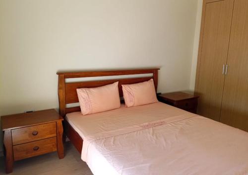 um quarto com uma cama com duas almofadas cor-de-rosa em Prestigia Opal 10 em Marrakech