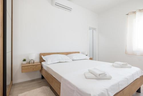 ein Schlafzimmer mit einem großen Bett mit weißer Bettwäsche und Handtüchern in der Unterkunft Villa Matea Nin - Adriatic Luxury Villas in Nin