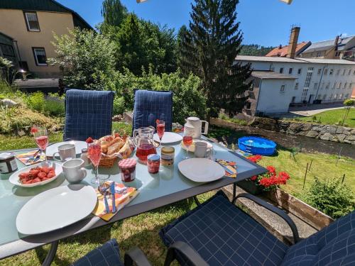 a picnic table with food and drinks on it at HW4B - Urlaubsmagie - Zentral mit Gemeinschaftsgarten, -Pool, -Sauna & Whirlpool in Sebnitz